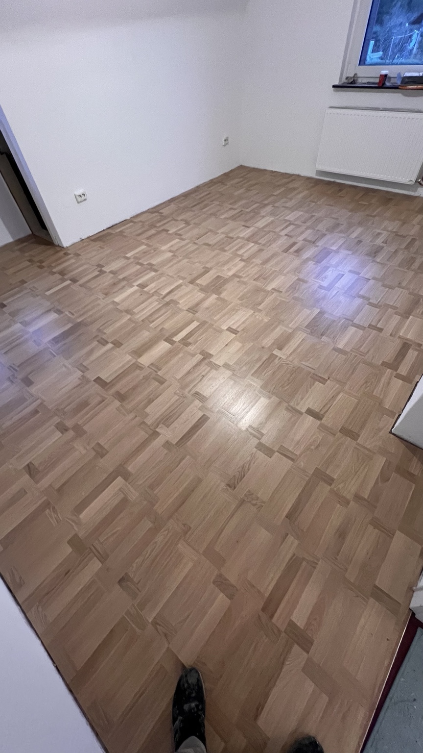 Verlegtes Parkett im Würfelmuster in einem hellen Raum