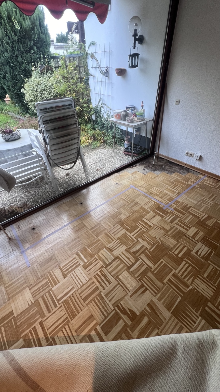 Würfelparkett vor der Reparatur im Bereich einer Terrassentür